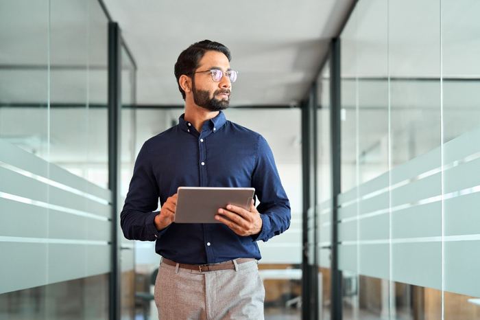 Professional reviewing strategy on a tablet in a modern office